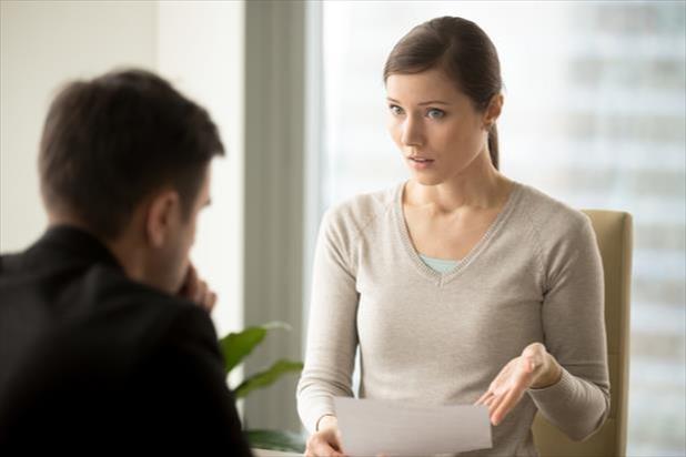 woman talking with employee behind desk