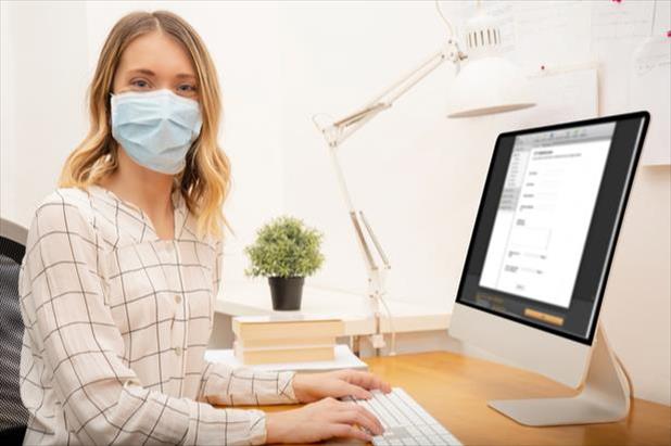 woman writing a job ad in a mask