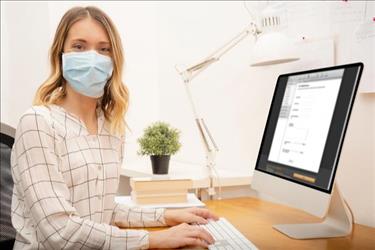 woman writing a job ad in a mask