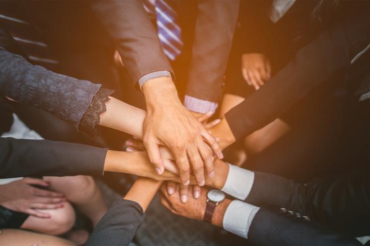 Group of employees with hands in the middle