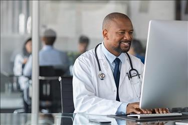 smiling doctor working on his computer