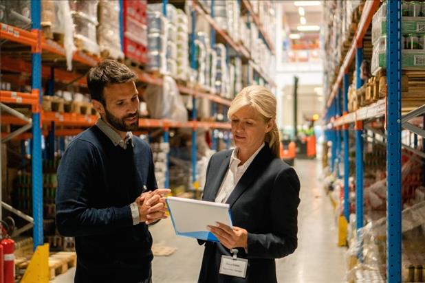 Logistics supervisor speaking to colleague