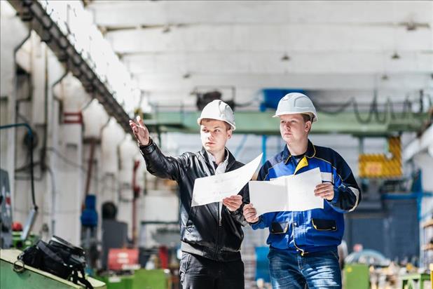 two construction project managers looking at plans on a work site