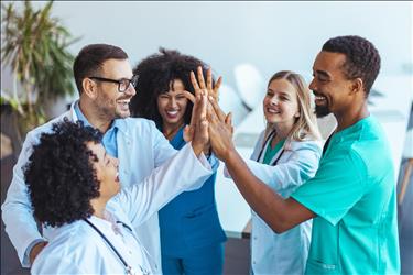 happy group of healthcare professionals giving high fives