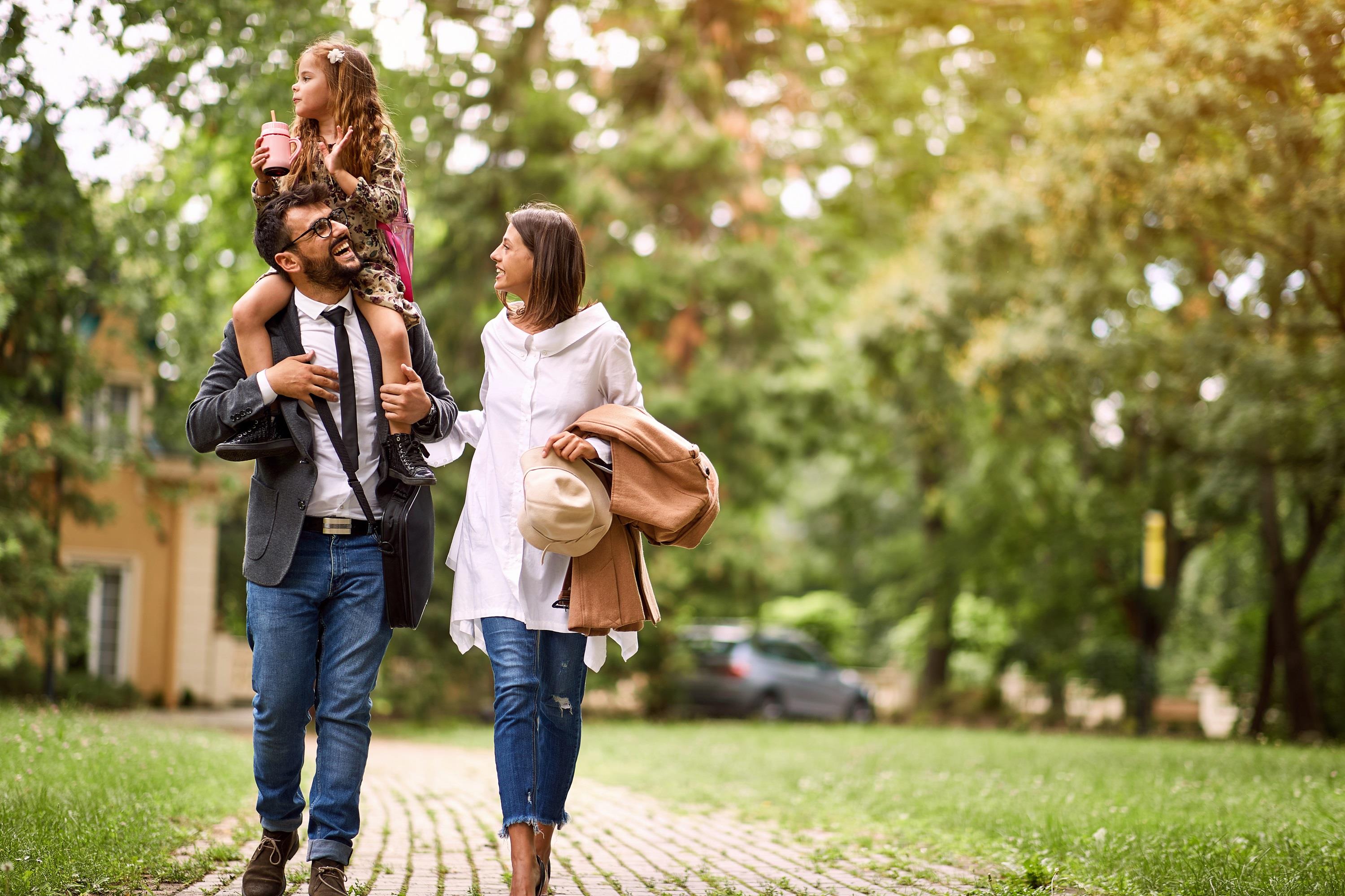 happy parents walking their child to school