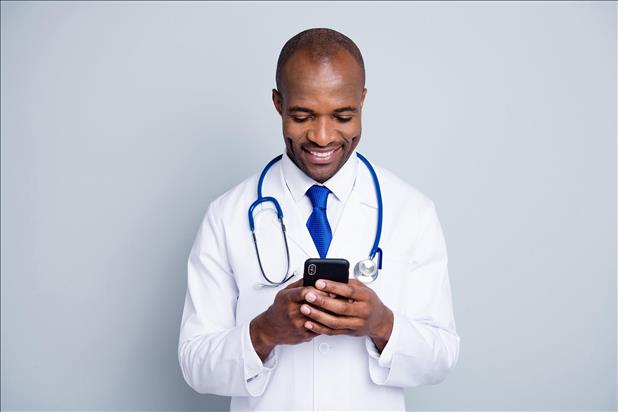 smiling doctor looking at his phone