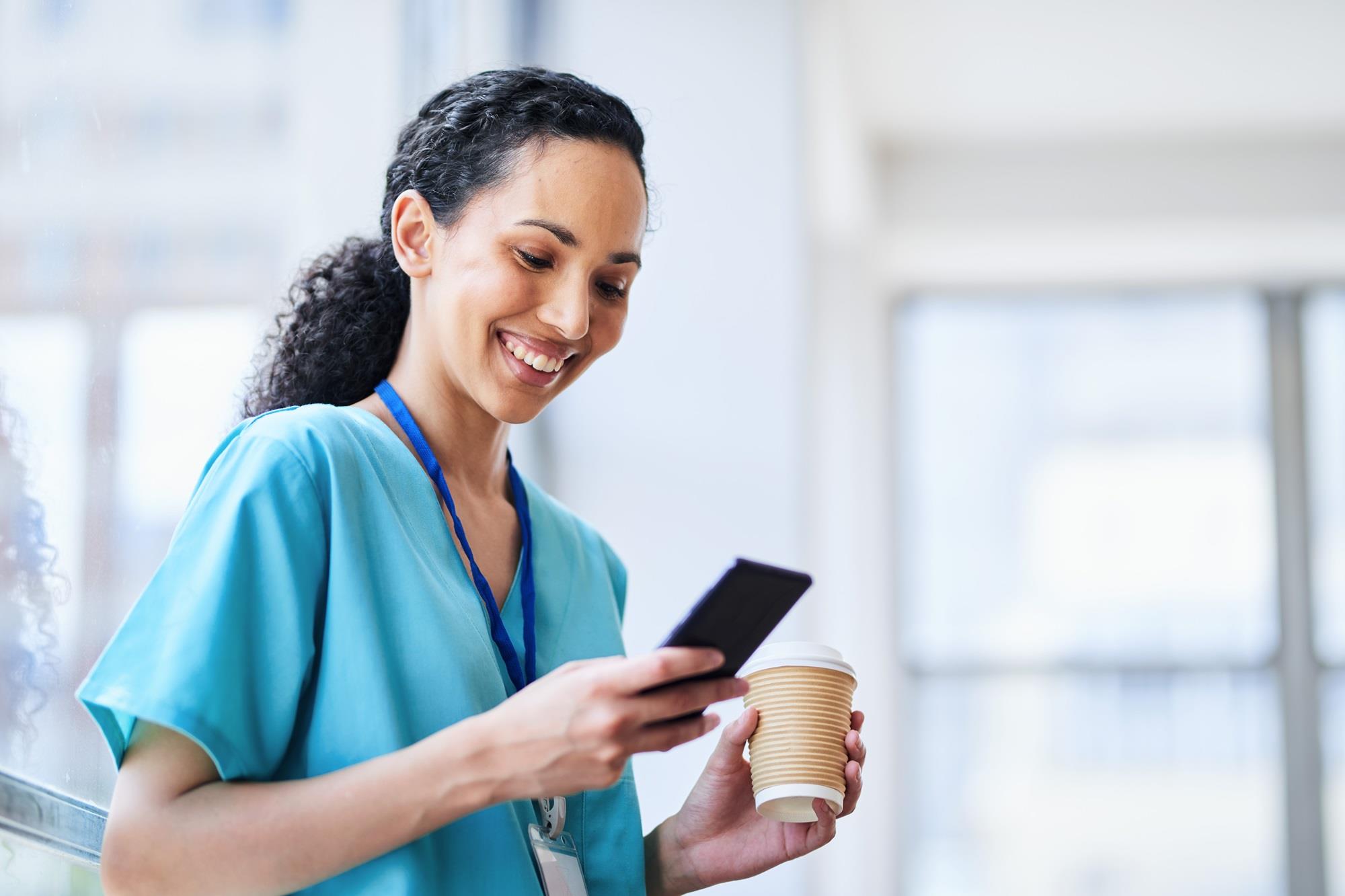 healthcare pro smiling while looking at her phone