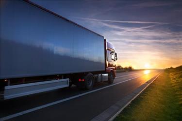 Long haul truck traveling across state lines as the sun sets