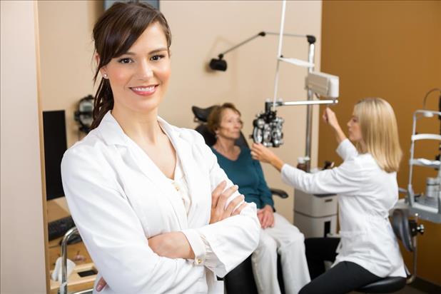 optometry mentor with her mentee in the background caring for a patient