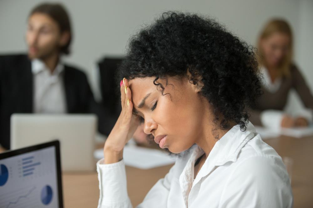 Exhausted professional suffering from a headache at her desk