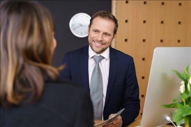 friendly receptionist greeting a customer at his desk