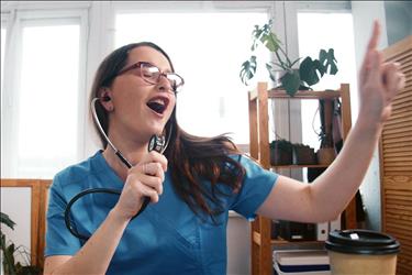 nurse pretending to sing with her stethoscope
