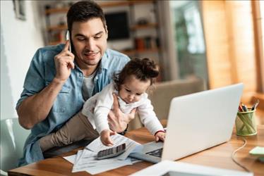 man working from home with his child