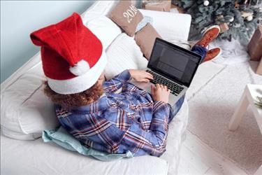 person on laptop with santa hat