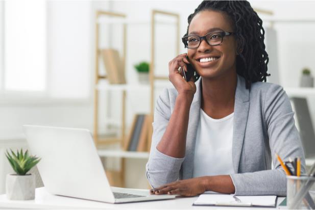 woman talking on phone at laptop