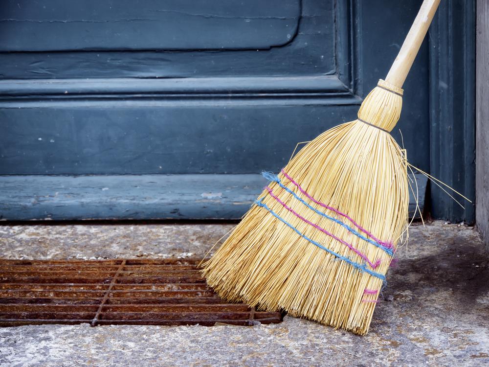 broom resting on a front porch