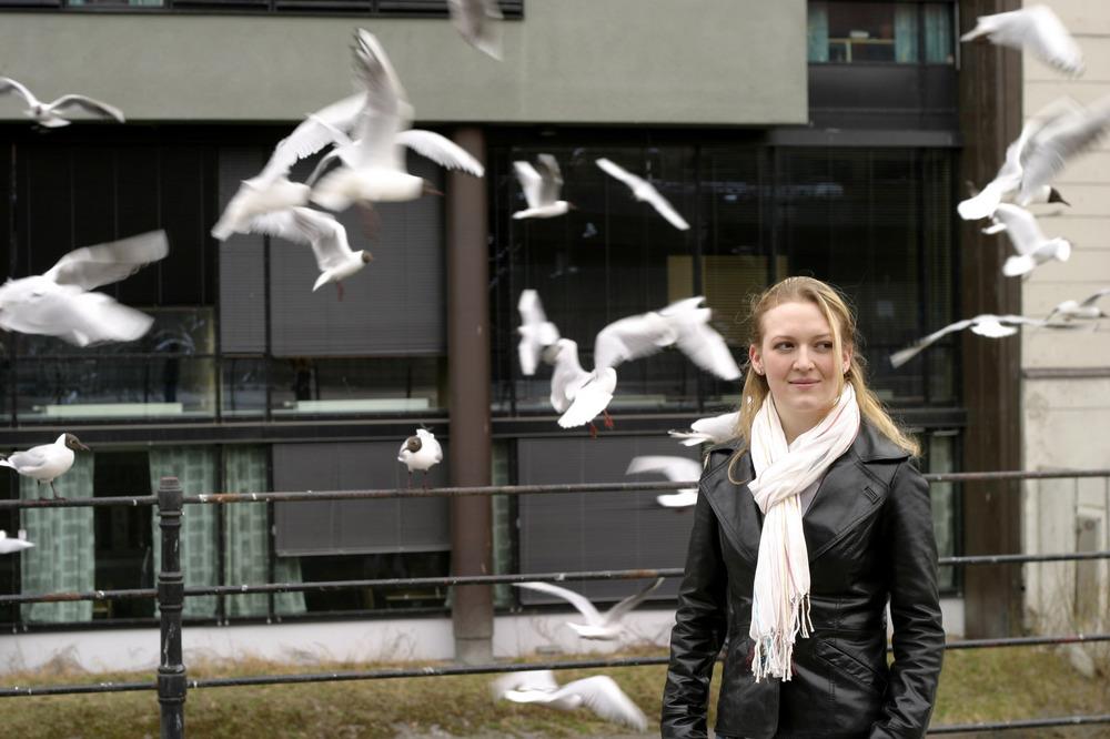 woman standing in a flock of birds