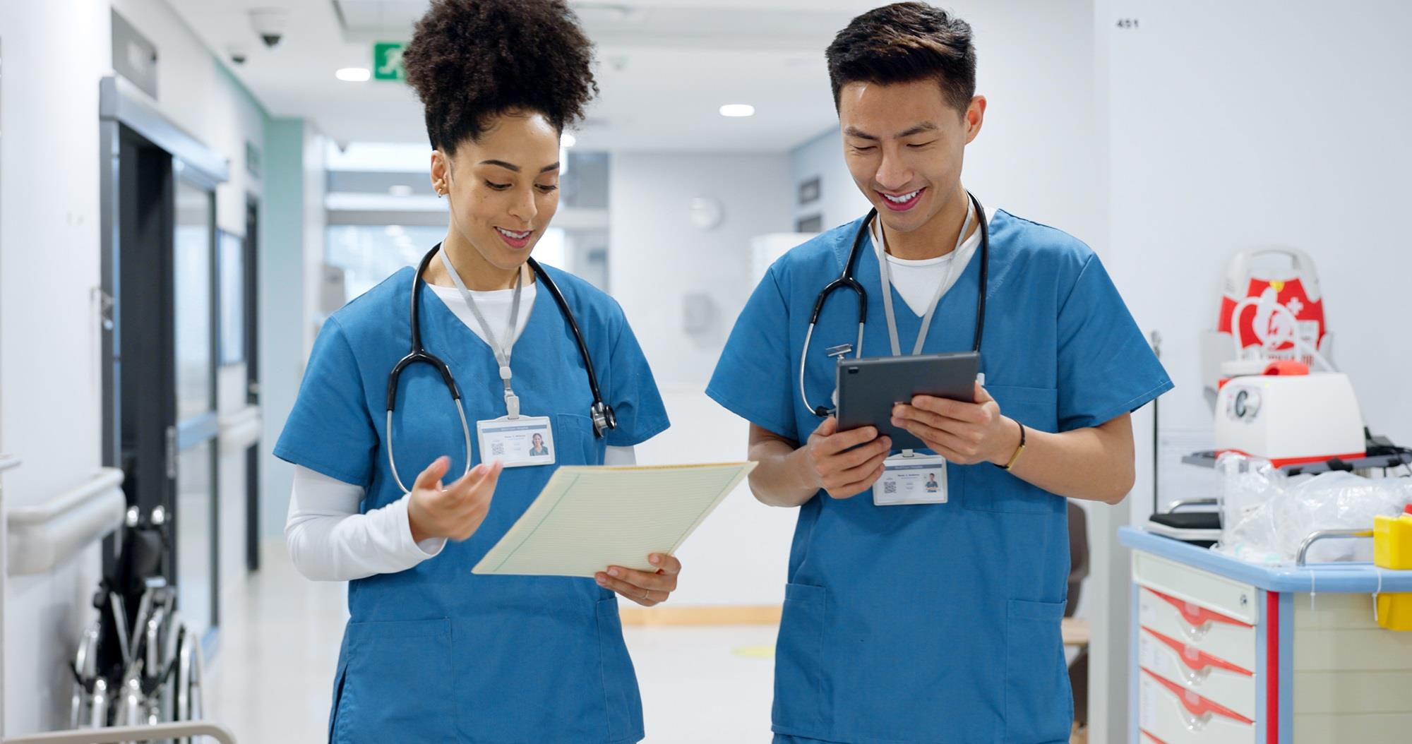 two smiling medical professionals walking together