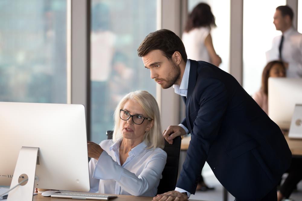 accountant showing her coworker financial data on her computer