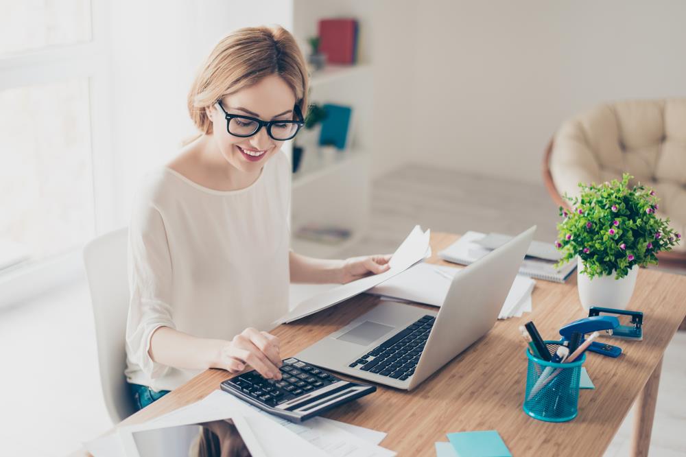 accountant at her desk doing calculations and reviewing figures