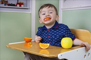 Young child eating oranges at lunchtime