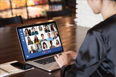 manager looking at screen with multiple employees on video chat