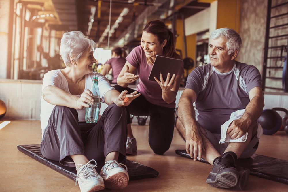 Personal trainer working with two older clients