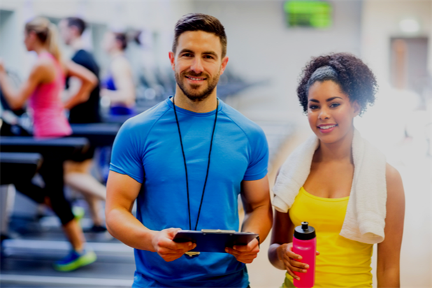 Two personal trainers posing in the gym