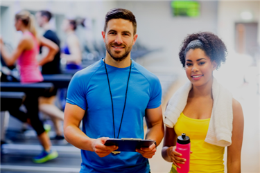 Two personal trainers posing in the gym