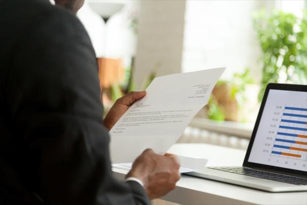 person looking at cover letter in front of computer