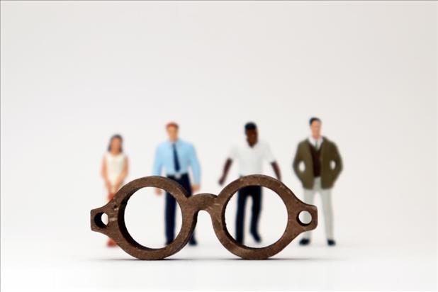 a pair of glasses in front of four job candidates