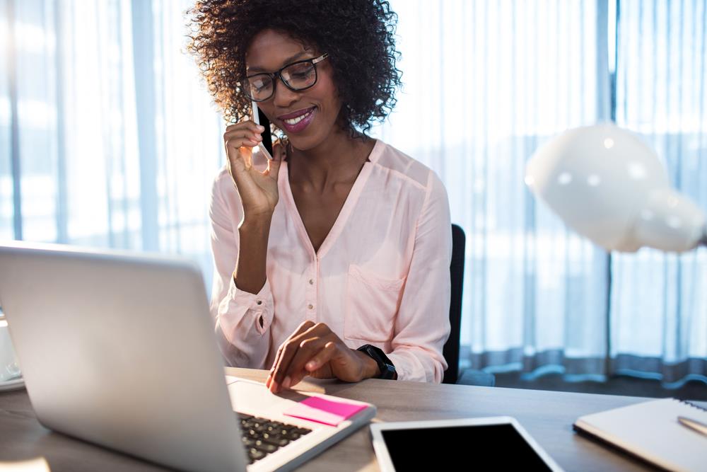 job seeker at her desk following up on an application via phone