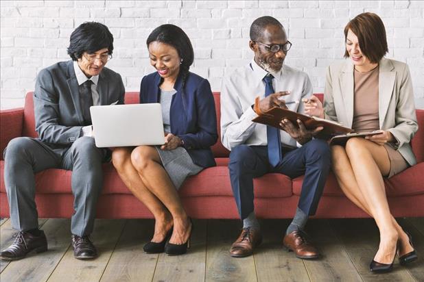 diverse workforce meeting together on an office couch