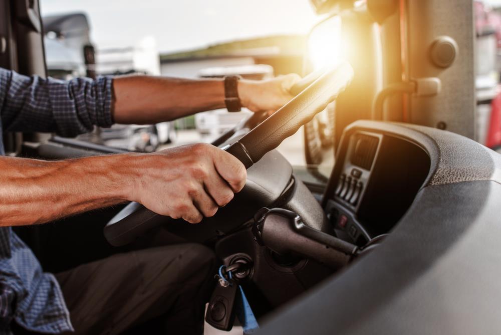 close-up of a cdl truck driver's hands on the wheel 