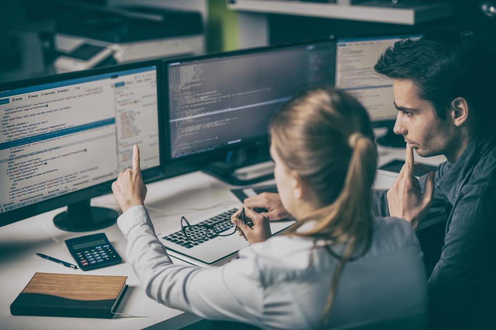 two software developers at a desk collaborating on a project