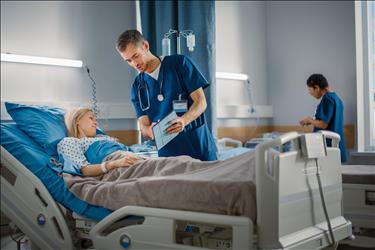 nurse showing info on his tablet to a hospital patient