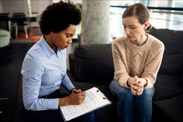 counselor talking to a patient and taking notes