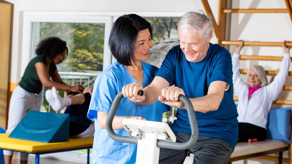 caregiver helping an elderly patient exercise