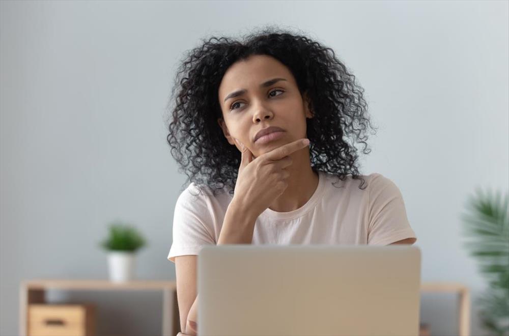 Woman thinking at laptop