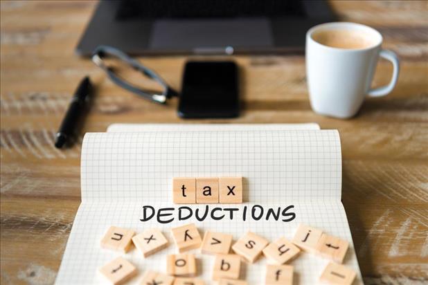 paper on a desk with tax deductions spelled out in ink and tiles