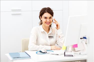 happy optometry office manager on the phone at her desk