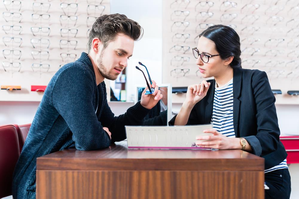 optical office manager meeting with a customer to review paperwork