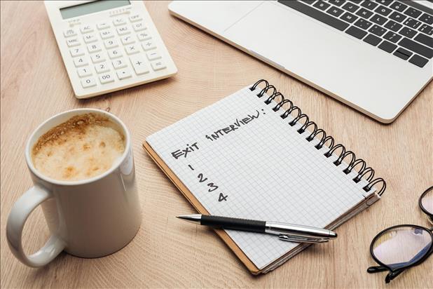 Handwritten Exit Interview planning in a spiral-bound notebook