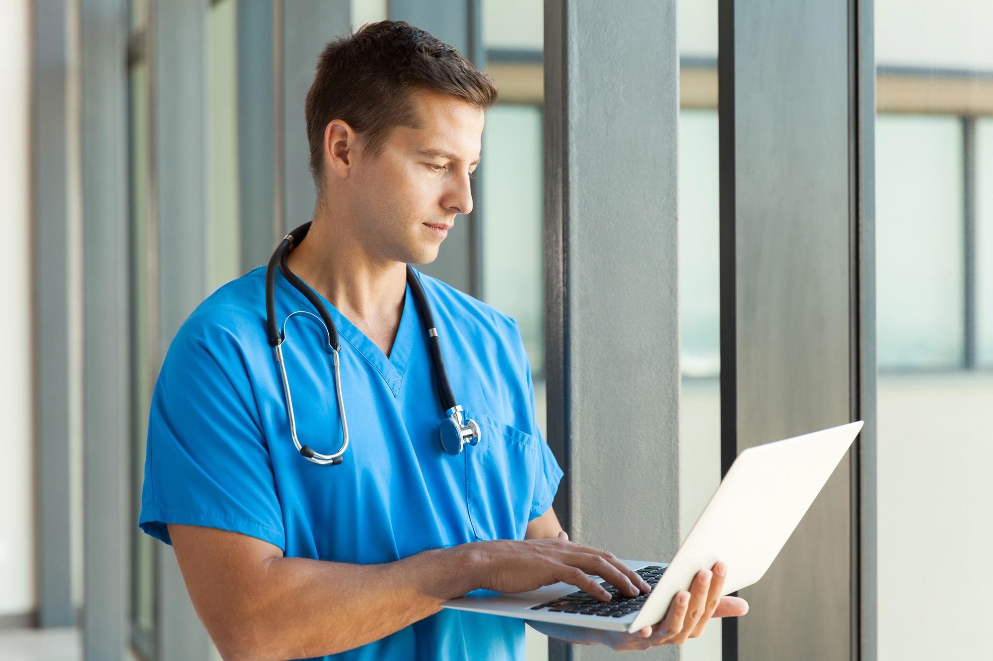 young nurse looking at his laptop