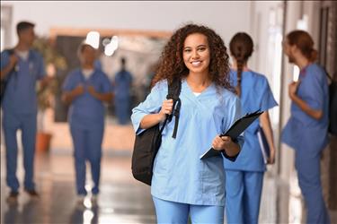 young nurse smiling with her backpack on