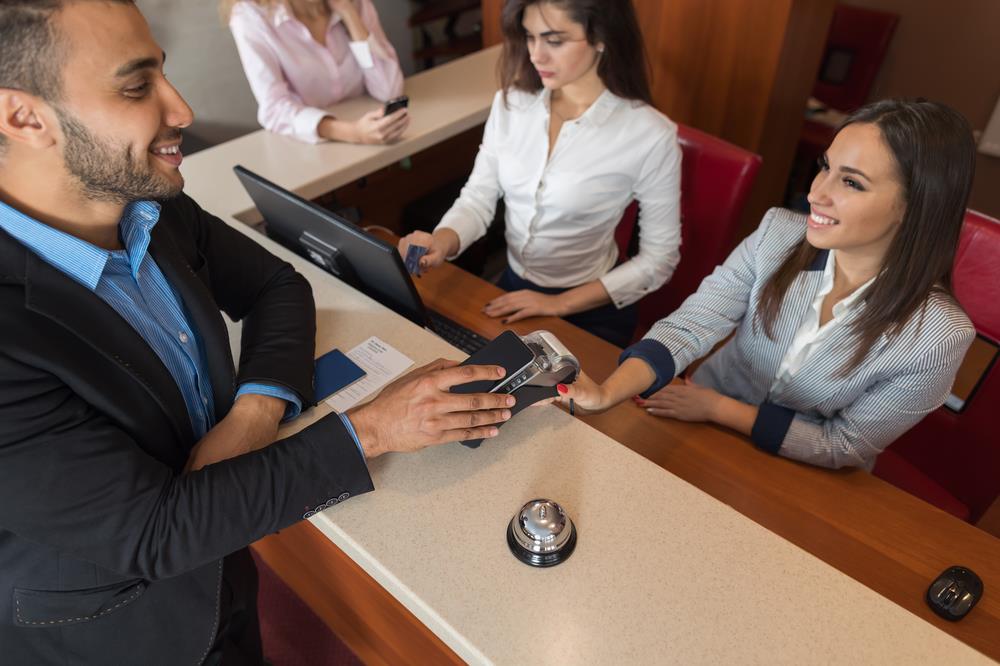 Millennial checking into a hotel using his smartphone