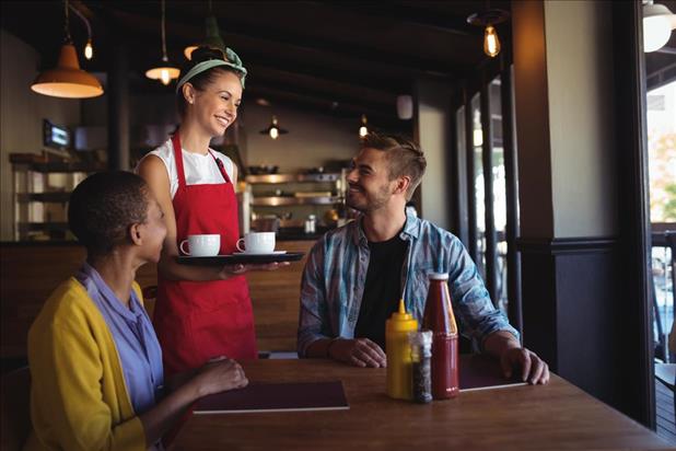 Friendly server talking to customers in a restaurant