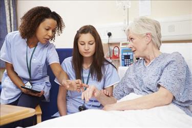 Image of nurse being mentored while examining a patient