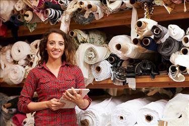 Small business owner posing in front of inventory