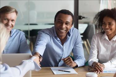 New hire shaking hands with a colleague at a meeting